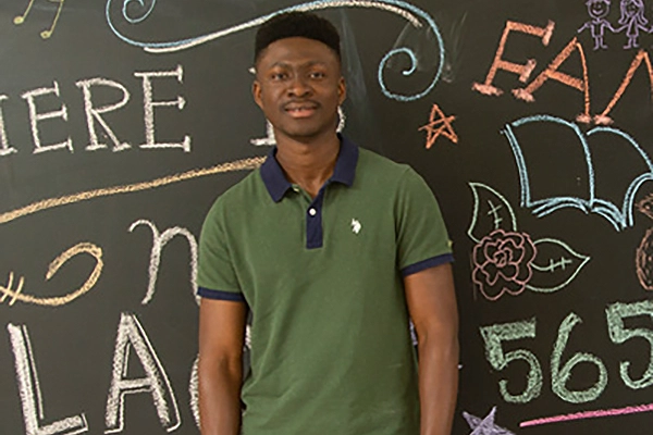 Student standing in front of colorful chalkboard